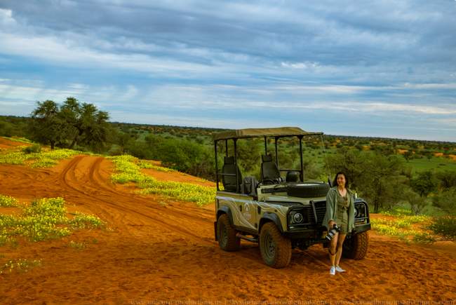 Olya with her camera beside an open safari vehicle